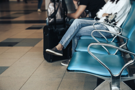 Airport waiting area, row of chairs, blurred people travellers wait for the flight in airport, departure terminalの写真素材