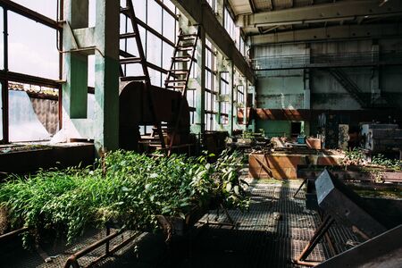 Abandoned factory inside, big windows, rusty steel equipment, post Soviet factory ruins