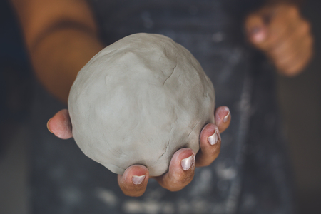 Pottery woman shows white clay, potter's hands, selective focus, tonedの写真素材
