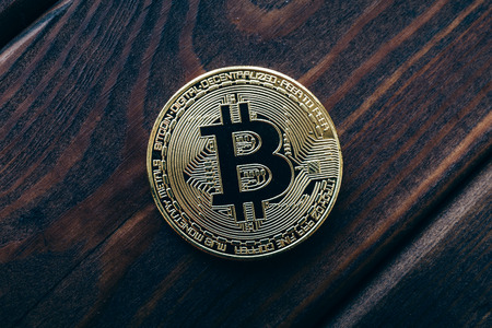 Top view of Bitcoin coin on wooden background, tonedの写真素材