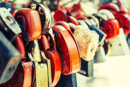 Many love locks locked on iron chain with perspective, selective focus with blurred background, padlocks - love, devotion, wedding sign and romance concept. Tonedの写真素材