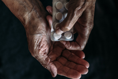 Hands of old woman with tablets or pills.  Health care and Taking medication of old people concept, top viewの写真素材