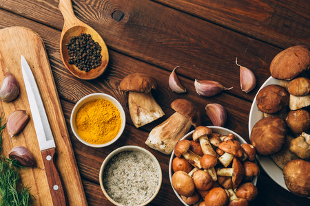 Ingredients for mushroom soup, mushrooms, garlic, spices on wooden table, top view, copy space. Autumn dinner and healthy organic food conceptの写真素材