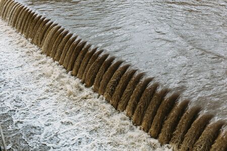 Powerful water flow on the man-made dam near the hydroelectric plantの写真素材