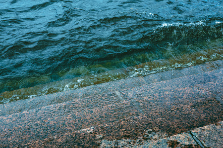 turquoise water of river splashes at marble stepsの写真素材