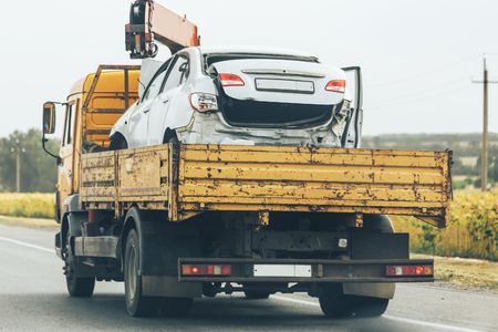 Tow truck transport smashed car after traffic accident, help on road transports wrecker broken carの写真素材