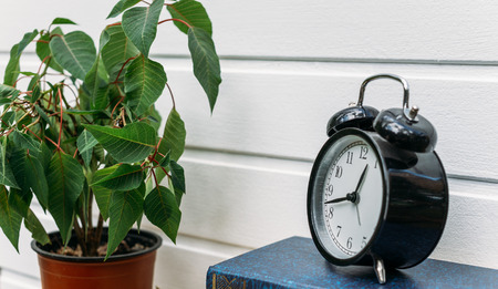 Retro alarm clock on white wooden wall background