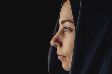 Muslim woman in hijab, close up portrait. European young girl in hijab looks forward, view from...