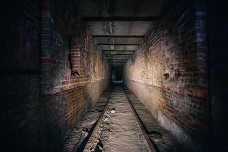 Dark scary corridor in abandoned industrial ruined brick factory, creepy interior, perspective tonedの写真素材