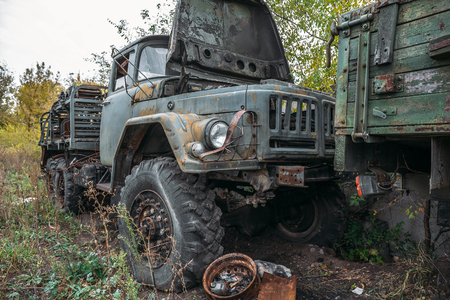 Old rusty abandoned truck, big grunge car among green grasの写真素材