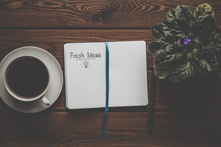 Fresh Ideas - words on open notebook on wooden table with cup of coffee, top view, retro toned. Inspire and Creativity Conceptの写真素材