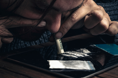 Man taking or sniffing drugs, snorting cocaine, Drug abuse conceptの写真素材