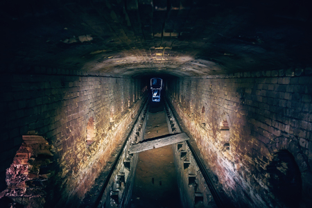 Abandoned underground sewer brick tunnel, dark dirty industrial corridor, tube perspective view, tonedの写真素材