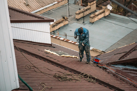 Unrecognised worker on modern roof, construction industry, view from aboveの写真素材