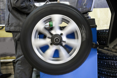 Process of balancing and fitting car tire wheel in motion, auto repair service, garage mechanicの写真素材