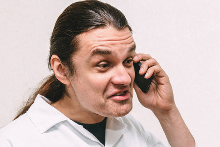 Funny crazy young man shouting at phone, expression and emotional portrait, tonedの写真素材