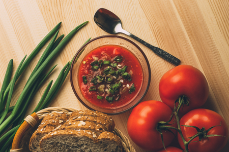 Tomato sauce in glass bowl, fresh bread, onion on wooden table, sauce ingredients for homemade  vegetarian healthy food, top viewの写真素材