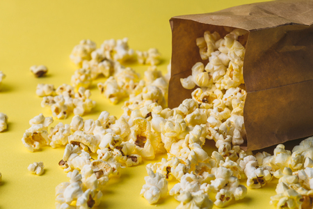 Popcorn in paper bag on yellow table, macro shotの写真素材