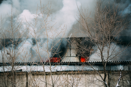 Fire in an industrial warehouse or Factory on Lantenskaya Street in Voronezh, rubber is burning, lots of smoke and flames, firefighters and MES rescue workers are struggling with a fireの写真素材