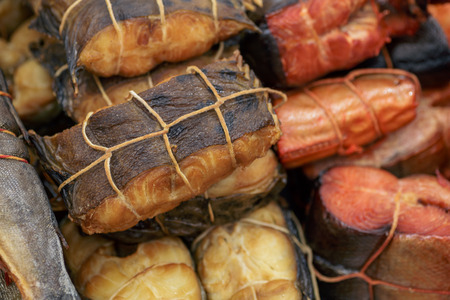 Various smoked fish tied with a tourniquet, prepared tasty seafood background, tonedの写真素材