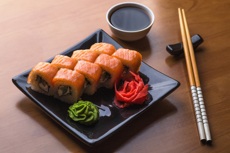 Set of Philadelphia Sushi Roll set on ceramic plate with wasabi, ginger, soy sauce and chopsticksの写真素材