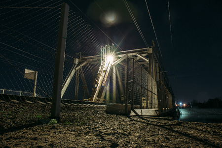 Railroad bridge over river at night, transportation construction, tonedの写真素材