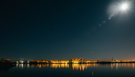 Panorama of city buildings lights reflection in water at night sky background and bright star, minimalism urban style.の写真素材