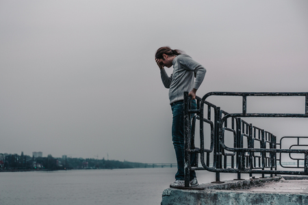 Depressed man is going to jump from bridge. Suicide concept, copy spaceの写真素材