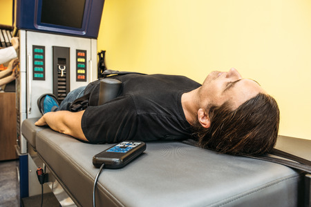 Man on treatment recovery physiotherapy of human spine by stretching with special medical equipment...