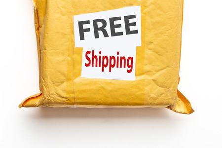 FREE Shipping text on yellow parcel package or cargo box with product, free logistic shipping and distribution at online internet shopping conceptの写真素材