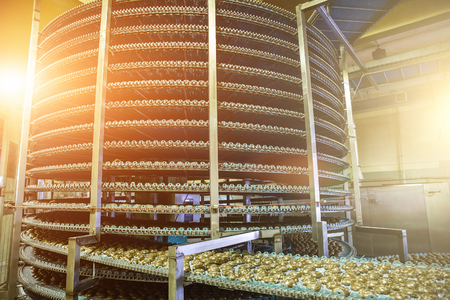 Big industrial automated round conveyor line or belt machine in bakery or confectionery food...