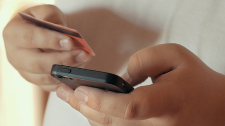 Mobile shopping concept or Online banking. Close up of male hand holding smartphone and credit card...