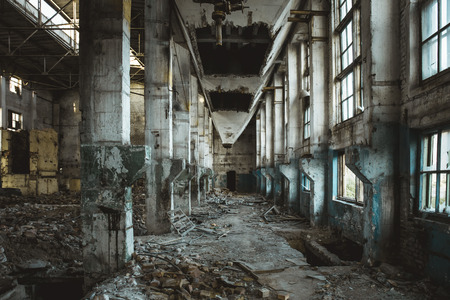 Ruins of abandoned old broken industrial factory or warehouse buildings inside after disaster, war...