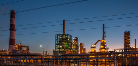 Oil refinery industrial plant or factory at sunset, storage distillery tanks and steel pipeline, modern petrochemical technologies, tonedの写真素材