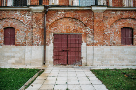 Steel gates or door in red brick wall with grass at ancient church, tonedの写真素材
