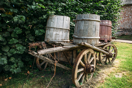 Vintage wooden cart with wooden buckets in rural farm in sunny summer or autumn day.の写真素材