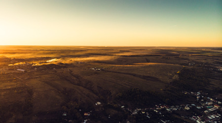 Aerial view of countryside village panorama in autumn sunset, tonedの写真素材