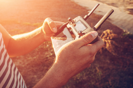 Man holding remote controller for flying on drone or quadcopter in hands, close upの写真素材