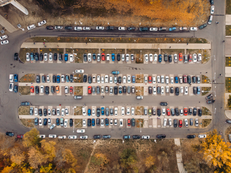 Outdoor parking lot or car park with rows of autos in urban landscape, aerial or top view, tonedの写真素材