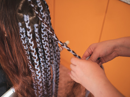 Girl head with braids from kanekalon material, creative hairstyle with thick plaits or pigtails also known as African or Afro braids, close upの写真素材