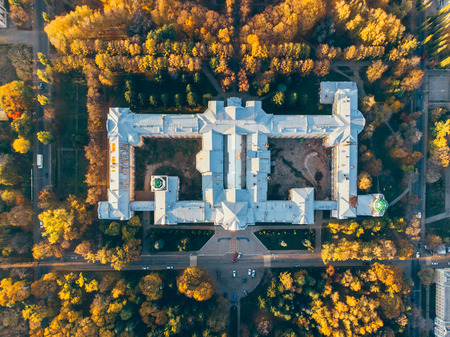 Top view of old building architecture in autumn city landscape with yellow trees and urban traffic,...