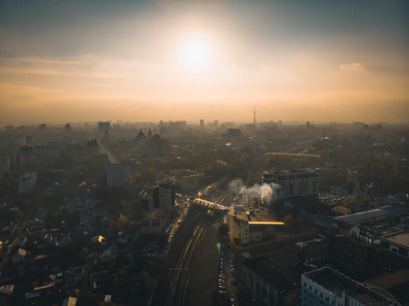 Aerial panorama of dramatic sunset above evening Voronezh city in haze or fog, bird eye view of urban downtown architecture in twilight, tonedの写真素材