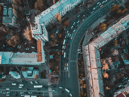 Aerial view of car traffic on city road from above. Drone photo of European downtown with buildings...