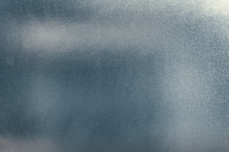 Dark silver background with blue tone, metal or aluminium foil texture as abstract backdrop for design.の写真素材
