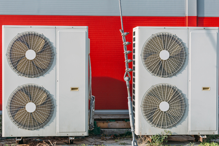 Air conditioners or HVAC or climate control systems on backyard of building, close upの写真素材