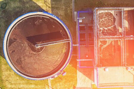 Aerial top view of round storage tank in water treatment and cleaning plant in sunset light, drone shot, tonedの写真素材