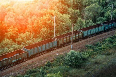Freight train drive fast, railway wagons in sunlight. Transportation, railroad, tonedの写真素材