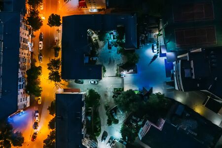 Top down view of night city buildings, yards and streets, aerial shot, tonedの写真素材