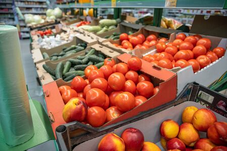 Fresh red organic tomatoes and other vegetables in farmers market or supermarket shelf, healthy food, selective focusの写真素材