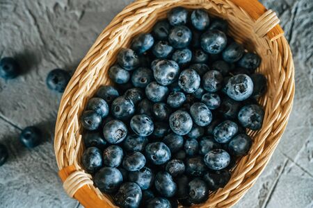 Fresh Blueberries in Wooden Basket on Table. Raw Organic Bilberry Close Up for Healthy Eating, Top Viewの写真素材